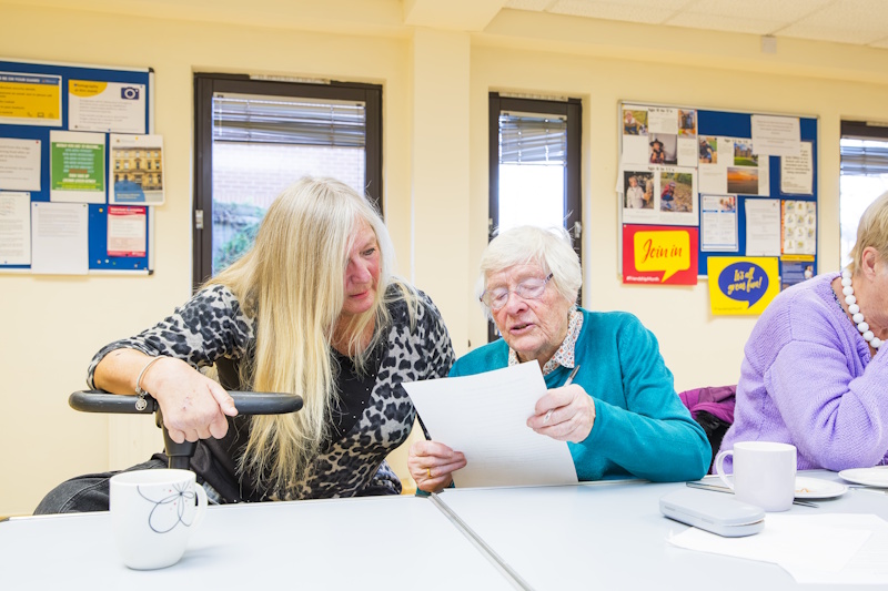 Two women looking at a piece of paper