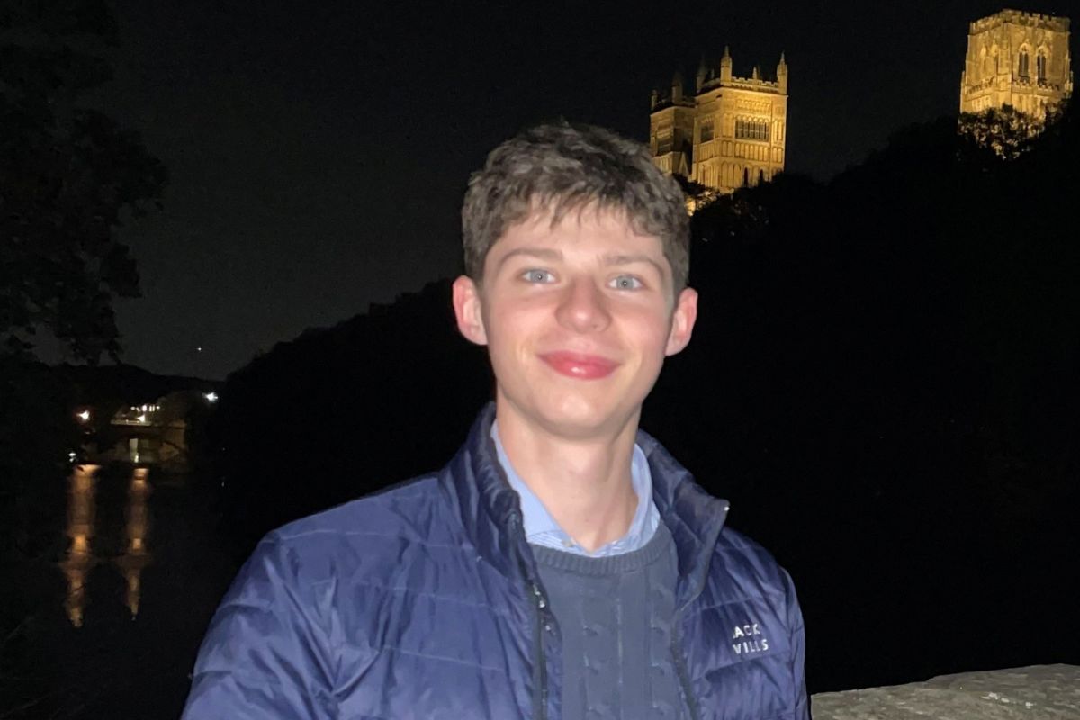 Will Stevenson smiles at the camera in front of a cathedral at night