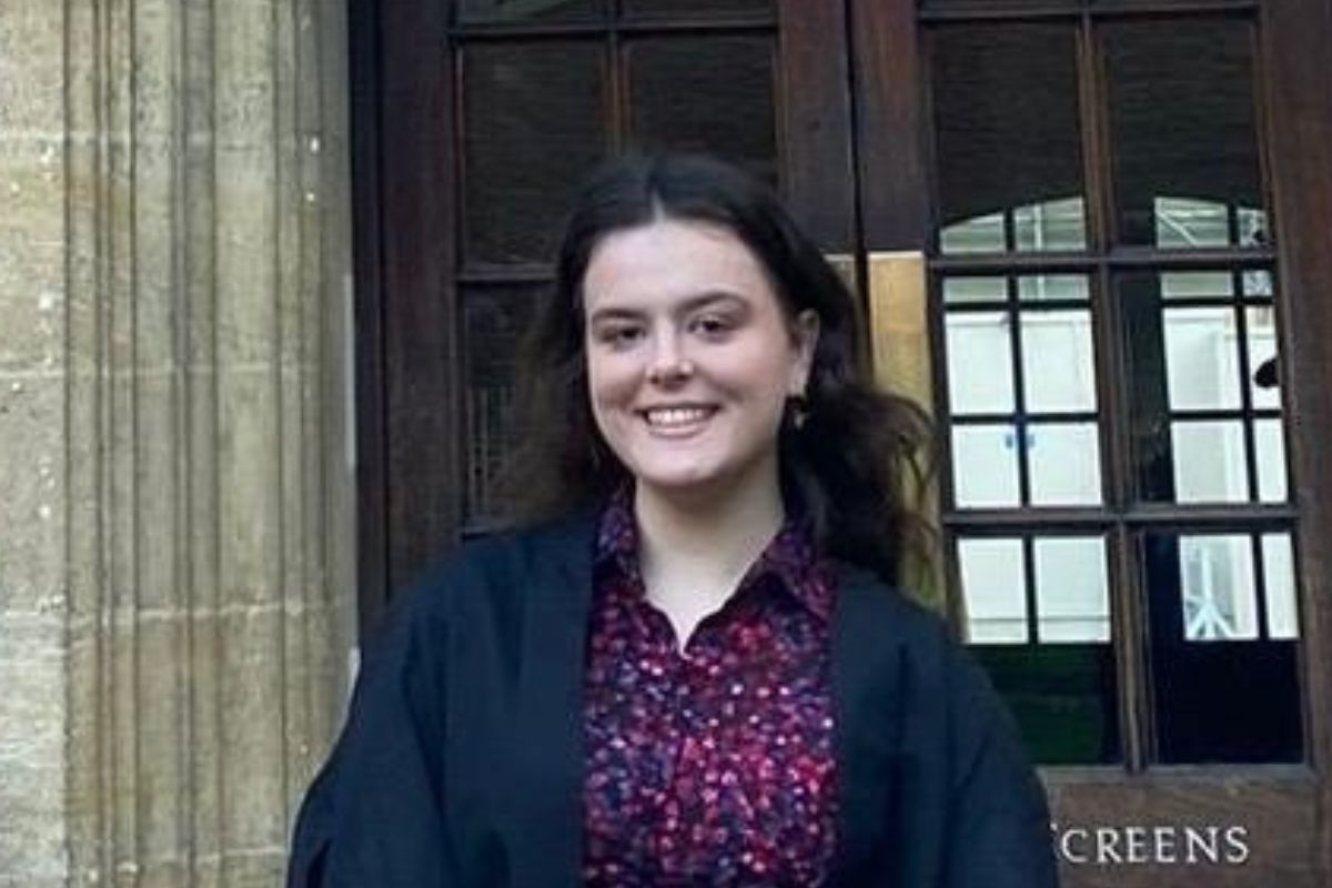 Melanie Healy smiles at the camera outside a university building